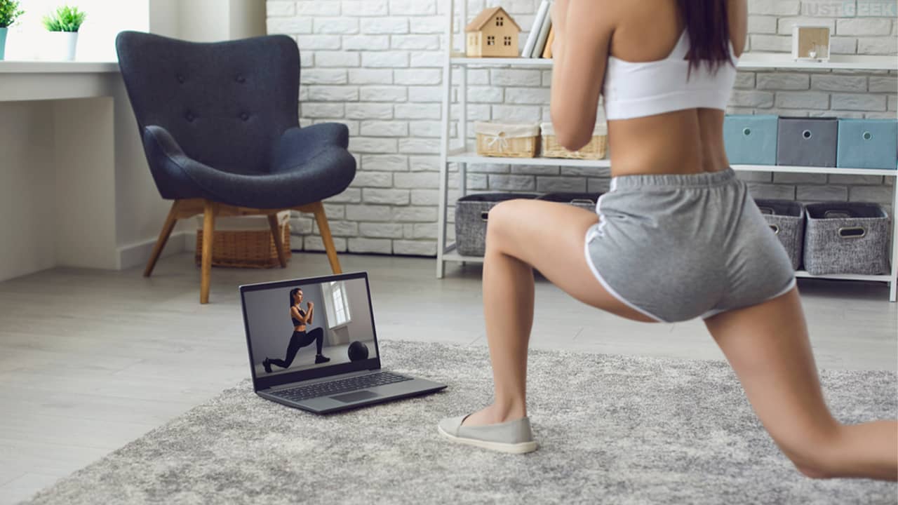 A young woman practicing sports at home in front of a computer